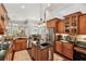 Open-concept kitchen boasts a center island with a sink, wood cabinets, and stainless-steel appliances at 5121 Delacroix Dr, Brooksville, FL 34604