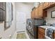 Laundry room with a new washer and dryer, white door, and wooden cabinets at 5121 Delacroix Dr, Brooksville, FL 34604