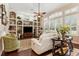 Bright living room with built-in shelving, a ceiling fan, and ample natural light at 5121 Delacroix Dr, Brooksville, FL 34604