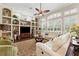 Spacious living room with built-in shelving, a ceiling fan, and a comfortable seating area at 5121 Delacroix Dr, Brooksville, FL 34604