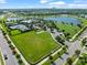 A birdseye view of a community green space, dog park, and tennis court, all adjacent to the lake at 6130 Colmar Pl, Apollo Beach, FL 33572