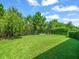 A sprawling backyard with lush green grass and a wrought iron fence offers privacy and space for outdoor enjoyment at 6130 Colmar Pl, Apollo Beach, FL 33572
