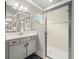 Modern bathroom with a glass shower, light gray cabinets, and a large mirror at 6130 Colmar Pl, Apollo Beach, FL 33572