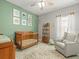 Bright Bedroom with a crib, plush chair, and charming decor for a comforting and stylish space at 6130 Colmar Pl, Apollo Beach, FL 33572