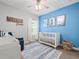 Bright Bedroom featuring a crib, plush chair, and blue accent wall to create a warm environment at 6130 Colmar Pl, Apollo Beach, FL 33572