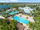 Aerial view of resort-style pool and recreation center, surrounded by lush landscaping and towering palm trees at 6130 Colmar Pl, Apollo Beach, FL 33572
