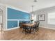 Dining room with a wood table, black chairs, unique light fixture, and wood floors at 6130 Colmar Pl, Apollo Beach, FL 33572