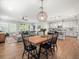 Charming dining area with wooden table and seating near the kitchen with white cabinets and a center island at 6130 Colmar Pl, Apollo Beach, FL 33572