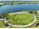 A picturesque view of a large round green space surrounded by palm trees and a walking path adjacent to a lake at 6130 Colmar Pl, Apollo Beach, FL 33572