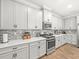 Bright kitchen featuring white cabinets, stainless steel appliances, quartz countertops, and a stylish backsplash at 6130 Colmar Pl, Apollo Beach, FL 33572