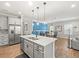 Open kitchen with a large island, stainless steel appliances, and view into the dining area with modern lighting at 6130 Colmar Pl, Apollo Beach, FL 33572