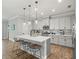 Well-lit kitchen with gray cabinets, stainless appliances, a center island with barstools, and wood-look tile flooring at 6130 Colmar Pl, Apollo Beach, FL 33572