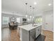 Open kitchen and dining area with a large island, modern lighting, stainless steel appliances, and wood-look flooring at 6130 Colmar Pl, Apollo Beach, FL 33572
