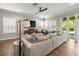 Bright living room with hardwood floors, gray sofa, and view of the outdoor patio at 6130 Colmar Pl, Apollo Beach, FL 33572