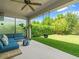 Relaxing covered patio overlooking the backyard offers ample seating and a swing for serene outdoor enjoyment at 6130 Colmar Pl, Apollo Beach, FL 33572