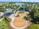 Overhead view of a community playground with swings and slides with a covered seating area nearby at 6130 Colmar Pl, Apollo Beach, FL 33572