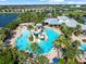 Resort-style community pool featuring water slides, plenty of room for swimming, and many palm trees for shade at 6130 Colmar Pl, Apollo Beach, FL 33572