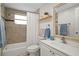 Bathroom featuring a shower/tub, light-colored tile, vanity and decorative mirror at 6144 Glenwood Dr, New Port Richey, FL 34653