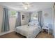 Bedroom with windows allowing natural light, and a bed with a blue pattern blanket at 6144 Glenwood Dr, New Port Richey, FL 34653