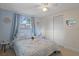 Bedroom with windows allowing natural light, and a bed with a blue pattern blanket at 6144 Glenwood Dr, New Port Richey, FL 34653
