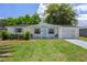 Charming single-story home with a well-manicured lawn, light blue accents, and attached two-car garage at 6144 Glenwood Dr, New Port Richey, FL 34653