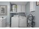 Efficient laundry area with washer, dryer, sink, and overhead storage, ready for immediate use at 6144 Glenwood Dr, New Port Richey, FL 34653