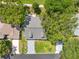 Aerial shot of a well-manicured home with a paved driveway, mature trees, and lush green grass at 6282 Darien Way, Spring Hill, FL 34606