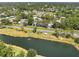 An aerial view of a charming neighborhood with a scenic pond, lush trees, and well-maintained homes at 6282 Darien Way, Spring Hill, FL 34606