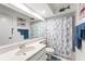 Bathroom featuring updated vanity, white tile flooring, and shower with ocean themed curtain at 6282 Darien Way, Spring Hill, FL 34606