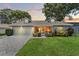Beautiful single-story home with dormer windows, a garage, and lush landscaping at dusk at 6282 Darien Way, Spring Hill, FL 34606