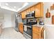 Efficient kitchen featuring stainless steel appliances, wood cabinets, light tile flooring, and ample counter space at 6282 Darien Way, Spring Hill, FL 34606
