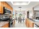 Bright eat-in kitchen boasting stainless steel appliances, tiled floors, wood cabinets, and ample natural light at 6282 Darien Way, Spring Hill, FL 34606