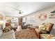 Inviting living room with tropical decor, wicker furniture, a ceiling fan, and a view into the kitchen at 6282 Darien Way, Spring Hill, FL 34606