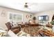 Comfortable living room featuring wicker furniture, tropical decor, and natural light from plantation shutters at 6282 Darien Way, Spring Hill, FL 34606