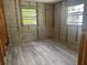 This bedroom features new vinyl floors, block wall construction, and two large windows letting in natural light at 6826 Driftwood Dr, Hudson, FL 34667