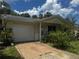 Exterior view of home showing the garage, driveway, and some landscaping at 6826 Driftwood Dr, Hudson, FL 34667