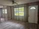 This living room features new vinyl floors, block wall construction, and a large window letting in natural light at 6826 Driftwood Dr, Hudson, FL 34667