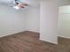 Bright bedroom showcasing wood flooring, a ceiling fan, and closet space for storage at 6932 Pin Cherry Ln, Port Richey, FL 34668