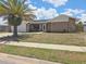 Charming single-story home featuring a lush palm tree, stone accents, and an attached two-car garage at 6932 Pin Cherry Ln, Port Richey, FL 34668