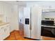 Bright kitchen featuring white cabinets and stainless steel refrigerator and range at 6932 Pin Cherry Ln, Port Richey, FL 34668