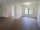 Bright living room with vinyl floors and natural light from a large window at 6932 Pin Cherry Ln, Port Richey, FL 34668