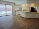 Open-concept living room with vinyl flooring and sliding glass doors to the pool area at 6932 Pin Cherry Ln, Port Richey, FL 34668