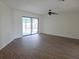 Open living room with ceiling fan and sliding glass door to backyard pool at 6932 Pin Cherry Ln, Port Richey, FL 34668