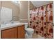 Cozy bathroom with a neutral color scheme, featuring a vanity, toilet, and shower with patterned curtain at 7059 Wirevine Dr, Brooksville, FL 34602