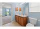 A bright bathroom features double sinks, wood cabinets, and tile flooring at 7059 Wirevine Dr, Brooksville, FL 34602