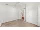 Vacant bedroom with carpet and an adjacent hallway with hardwood flooring at 7059 Wirevine Dr, Brooksville, FL 34602