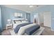 A well-lit main bedroom features a large bed, a ceiling fan, and soothing blue walls at 7059 Wirevine Dr, Brooksville, FL 34602