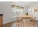 A bright dining area with a round table and chairs, illuminated by a modern pendant light at 7059 Wirevine Dr, Brooksville, FL 34602