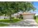 Single-story home with a well-manicured lawn and a driveway leading to a two-car garage at 7059 Wirevine Dr, Brooksville, FL 34602