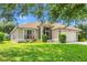 Charming single-story home with well-manicured lawn, landscaping, and a screened porch entry at 7059 Wirevine Dr, Brooksville, FL 34602
